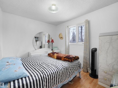 Bedroom with wood finished floors, a textured ceiling, and arched walkways - 17122 96 Street, Edmonton, AB - Indoor Photo Showing Bedroom