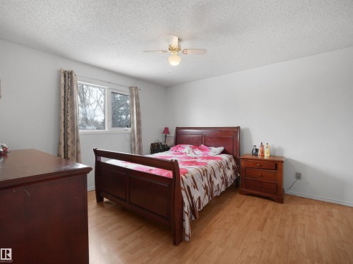 Bedroom featuring light wood-type flooring, a textured ceiling, and a ceiling fan - 17122 96 Street, Edmonton, AB - Indoor Photo Showing Bedroom
