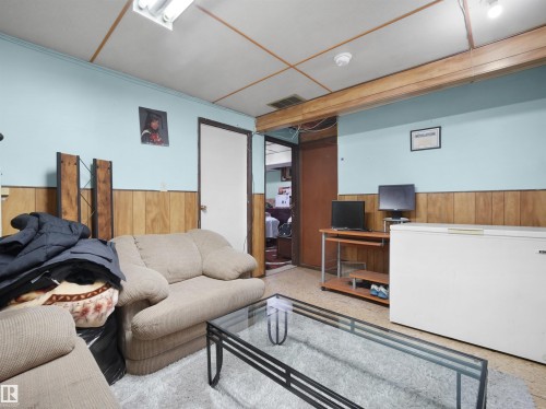 Living area featuring wood walls and a wainscoted wall - 17122 96 Street, Edmonton, AB - Indoor