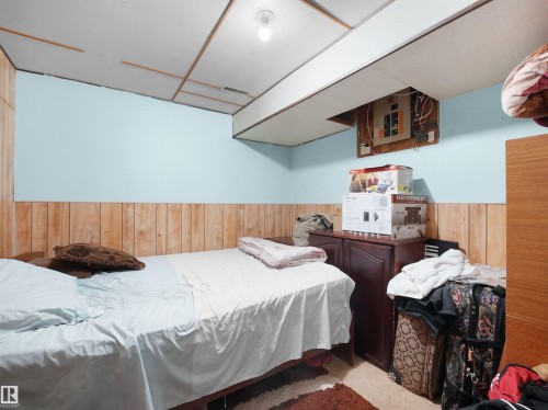 Carpeted bedroom featuring wood walls and wainscoting - 17122 96 Street, Edmonton, AB - Indoor Photo Showing Bedroom