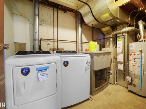 Laundry area with gas water heater, concrete floors, and washer and clothes dryer - 17122 96 Street, Edmonton, AB - Indoor Photo Showing Basement