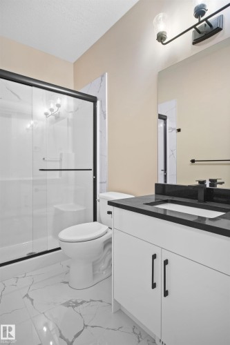 Bathroom with vanity, a shower stall, a textured ceiling, and light marble finish floors - 3910 41 Avenue, Beaumont, AB - Indoor Photo Showing Bathroom
