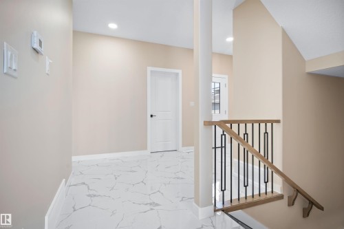 Hall featuring light marble finish floors, recessed lighting, and an upstairs landing - 3910 41 Avenue, Beaumont, AB - Indoor Photo Showing Other Room