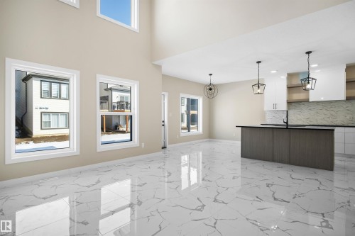 Unfurnished living room featuring baseboards and light marble finish flooring - 3910 41 Avenue, Beaumont, AB - Indoor