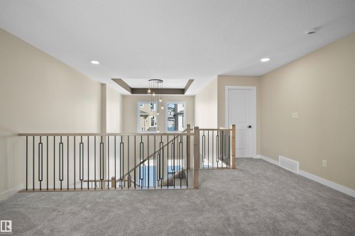 Hall with carpet flooring, an upstairs landing, a raised ceiling, and recessed lighting - 3910 41 Avenue, Beaumont, AB - Indoor Photo Showing Other Room