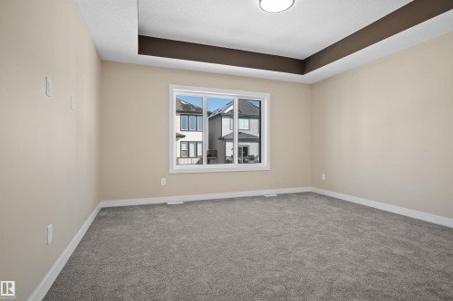 Carpeted spare room with a tray ceiling and baseboards - 3910 41 Avenue, Beaumont, AB - Indoor Photo Showing Other Room