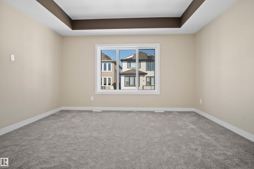 Carpeted empty room with baseboards and a tray ceiling - 3910 41 Avenue, Beaumont, AB - Indoor Photo Showing Other Room