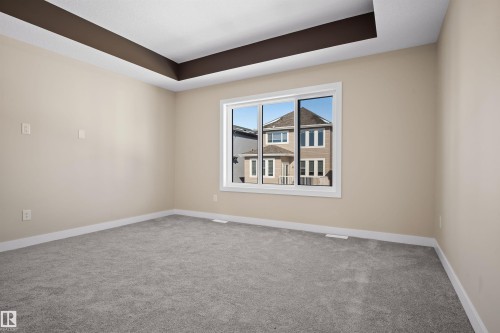 Spare room featuring a tray ceiling and carpet floors - 3910 41 Avenue, Beaumont, AB - Indoor Photo Showing Other Room