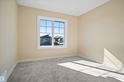 Unfurnished room with light colored carpet and baseboards - 3910 41 Avenue, Beaumont, AB - Indoor Photo Showing Other Room