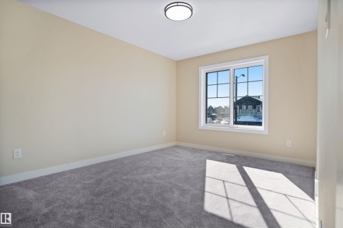 Carpeted spare room featuring baseboards - 3910 41 Avenue, Beaumont, AB - Indoor Photo Showing Other Room