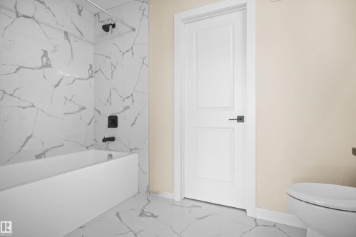 Bathroom featuring light marble finish flooring and a combined bath / shower with marble appearance - 3910 41 Avenue, Beaumont, AB - Indoor Photo Showing Bathroom