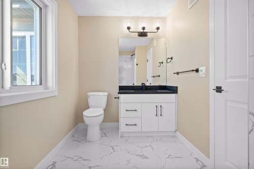Bathroom featuring light marble finish flooring, vanity, and a shower - 3910 41 Avenue, Beaumont, AB - Indoor Photo Showing Bathroom