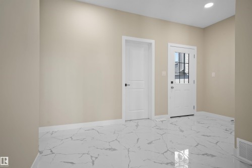 Entrance foyer with light marble finish floors and recessed lighting - 3910 41 Avenue, Beaumont, AB - Indoor Photo Showing Other Room