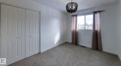 Unfurnished bedroom with hanging lights, a closet, and light carpet - 