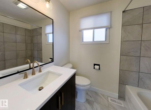 Full bathroom featuring vanity, shower / bathtub combination, and light marble finish floors - 1102 55 Street, Edson, AB - Indoor Photo Showing Bathroom