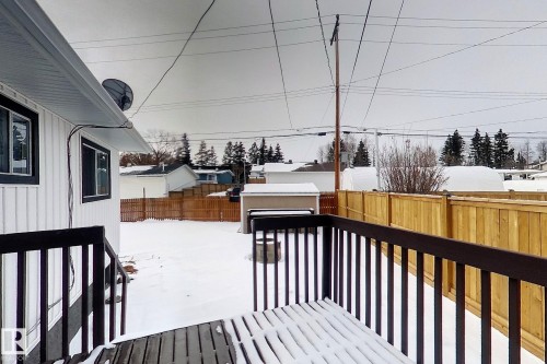 Snow covered deck with a fenced backyard and an outdoor structure - 1102 55 Street, Edson, AB - Outdoor With Exterior