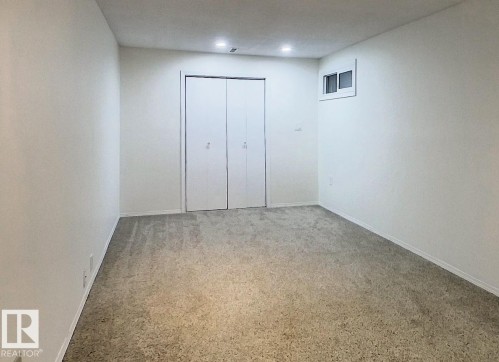 Unfurnished bedroom featuring carpet flooring and a closet - 1102 55 Street, Edson, AB - Indoor Photo Showing Other Room
