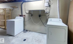 Laundry area featuring unfinished concrete floors and washer and clothes dryer - 