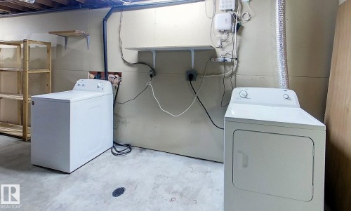 Laundry area featuring unfinished concrete floors and washer and clothes dryer - 1102 55 Street, Edson, AB - Indoor Photo Showing Laundry Room