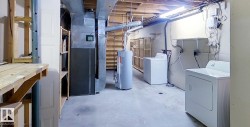 Unfinished basement with heating unit and water heater - 