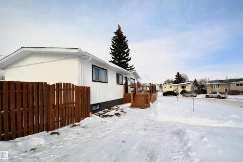 View of snow covered exterior featuring a wooden deck and a residential view - 1102 55 Street, Edson, AB - Outdoor