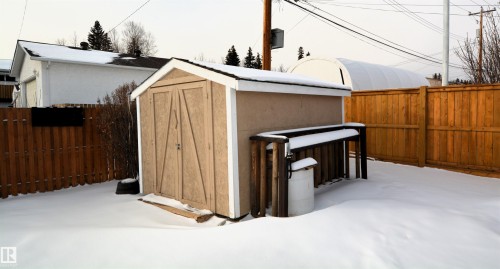 Snow covered structure featuring a fenced backyard and a shed - 1102 55 Street, Edson, AB - Outdoor With Exterior