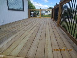 Spacious wood plank decking with a durable wood and metal railing system - 