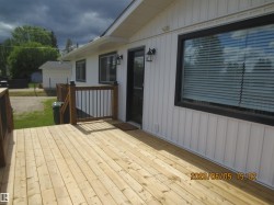 Spacious wood plank deck with dark wood-finish railings and black metal balusters - 