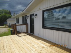Expansive wooden deck with a dark wood railing and black balusters - 