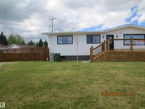 White vertical siding exterior with black trim windows - 1102 55 Street, Edson, AB 