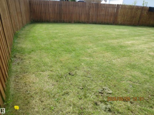 Expansive fenced lawn area featuring natural wood privacy fencing - 1102 55 Street, Edson, AB 