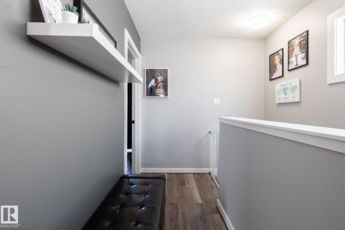 Corridor with an upstairs landing, dark wood-style floors, and a textured ceiling - 1710 Keene Crescent. Sw, Edmonton, AB - Indoor Photo Showing Other Room