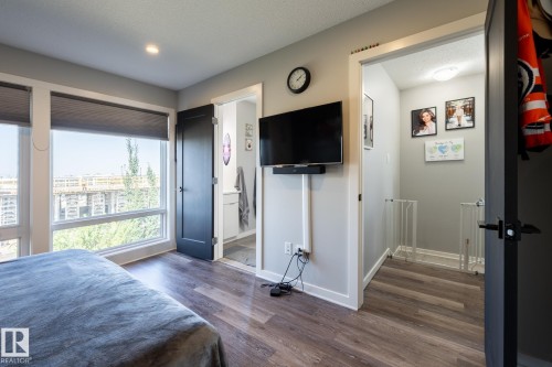 Bedroom with dark wood-type flooring, ensuite bathroom, and a textured ceiling - 1710 Keene Crescent. Sw, Edmonton, AB - Indoor Photo Showing Bedroom