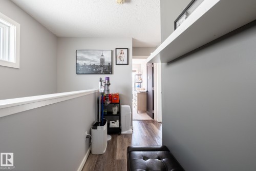 Hall featuring wood finished floors, a textured ceiling, and plenty of natural light - 1710 Keene Crescent. Sw, Edmonton, AB - Indoor Photo Showing Other Room