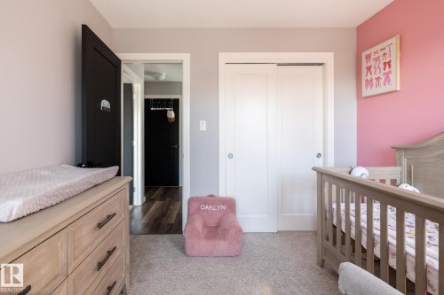 Bedroom featuring a closet, a crib, and light carpet - 1710 Keene Crescent. Sw, Edmonton, AB - Indoor Photo Showing Bedroom