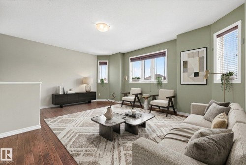 Living area with baseboards and dark wood-style floors - 152 Rue Marquet, Beaumont, AB - Indoor Photo Showing Living Room