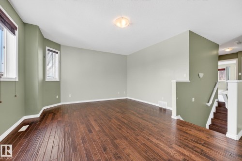 Spare room featuring stairway and dark wood-type flooring - 152 Rue Marquet, Beaumont, AB - Indoor Photo Showing Other Room