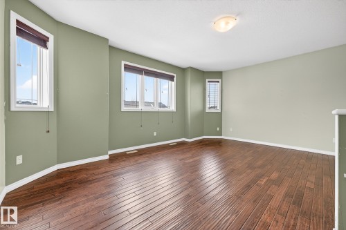 Empty room with dark wood-style floors - 152 Rue Marquet, Beaumont, AB - Indoor Photo Showing Other Room
