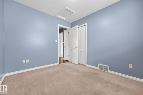 Unfurnished bedroom featuring attic access and carpet floors - 152 Rue Marquet, Beaumont, AB - Indoor Photo Showing Other Room