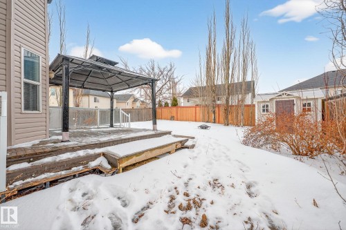 Snowy yard featuring a gazebo, a fenced backyard, and a deck - 152 Rue Marquet, Beaumont, AB - Outdoor
