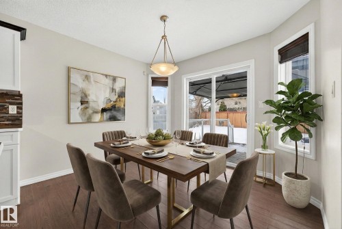 Dining area featuring dark wood-style floors and baseboards - 152 Rue Marquet, Beaumont, AB - Indoor Photo Showing Dining Room