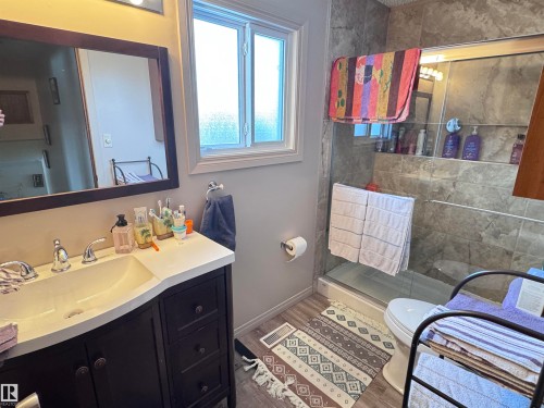 Bathroom with vanity, a stall shower, and wood finished floors - 10503 110 Street, Westlock, AB 