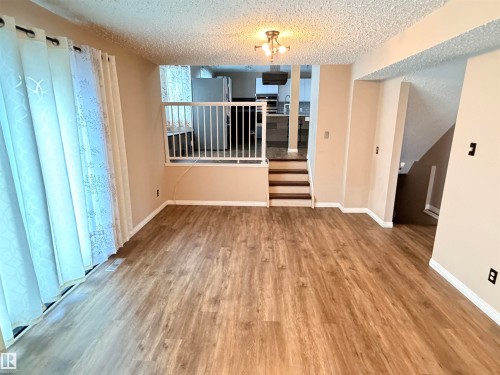 Wood-finish flooring throughout, with neutral wall paint and white trim - 10503 110 Street, Westlock, AB 
