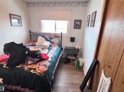 Bedroom with wood finished floors and wallpapered walls - 