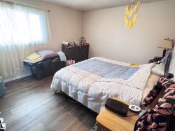 Bedroom with a textured ceiling and wood finished floors - 
