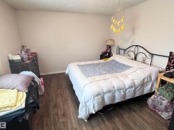 Bedroom featuring dark wood finished floors and a textured ceiling - 