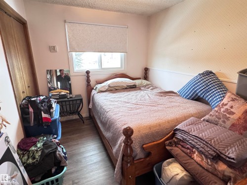 Bedroom with a closet, a textured ceiling, and wood finished floors - 10503 110 Street, Westlock, AB 