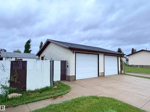 Detached two-car garage with white paneled doors and a dark shingle roof - 10503 110 Street, Westlock, AB 