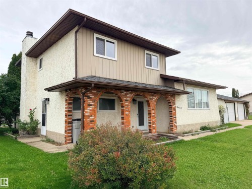Stucco exterior with brick archway detailing, multi-pane windows, and a three-car garage - 10503 110 Street, Westlock, AB 