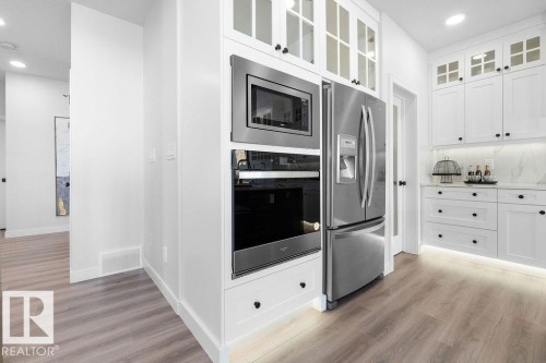 Kitchen featuring recessed lighting, stainless steel appliances, white cabinets, and light wood-style flooring - 3722 41 Avenue, Beaumont, AB - Indoor Photo Showing Kitchen